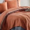 Set cuvertura 220x240cm cu cearceaf pat si fete perna cu ciucuri Bohemline V2 din bumbac caramiziu/gri, expus pe pat