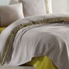 Set cuvertura 220x240cm cu cearceaf pat si fete perna cu ciucuri Bohemline V3 din bumbac bej/mustar, expus pe pat