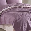 Set cuvertura 220x240cm cu cearceaf pat si fete perna cu ciucuri Bohemline V7 din bumbac mov/roz, expus pe pat