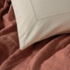 Set Vilo Caramiziu – cuvertură pique caramizie și fețe pernă bej brodate, expus pe pat