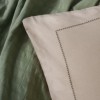 Set Vilo Verde – cuvertură pique verde și fețe pernă bej brodate, expus pe pat