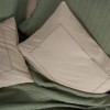 Set Vilo Verde – cuvertură pique verde și fețe pernă bej brodate, expus pe pat