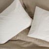 Set Vilo Bej – cuvertură pique texturată și fețe pernă brodate, expus pe pat în decor natural