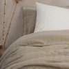 Set Vilo Bej – cuvertură pique texturată și fețe pernă brodate, expus pe pat în decor natural