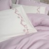 SetVaila lila – cuvertură pique lyocell/bumbac, cearceaf satinat și 4 fețe pernă brodate, expus pe pat