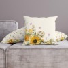 Față de pernă decorativă din bumbac 100%, cu iepurași printre floarea-soarelui și fluturi pastel, perfectă pentru decorul de Paște.
