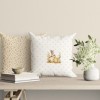 Față de pernă decorativă din bumbac 100%, 45x45cm, cu iepuraș lângă ouă de Paște, fluturi și fundal cu detalii florale delicate, ideală pentru decor festiv.
