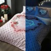 Lenjerie de pat dublu bumbac 100% Ranforce Tac Lover fosforescentă cu imprimeu floral și buline negre pe fundal roz, strălucind în întuneric.