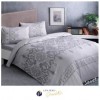 Lenjerie de pat dublu bumbac 100% Ranforce, design elegant cu motive baroc gri pe fundal alb.