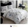 Lenjerie de pat dublu bumbac 100% Ranforce, design floral elegant cu fluturi albastri și motive gri și negre pe fundal alb.
