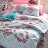 Lenjerie de pat dublu din bumbac 100% ranforce, cu design tradițional multicolor pe fond alb și roz.
