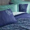 Lenjerie de pat dublu din bumbac 100% ranforce, model Cadee Mint, cu design floral și geometric în nuanțe de albastru marin și mentă pe fundal albastru.