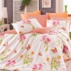 Lenjerie de pat din bumbac 100% ranforce cu model floral în nuanțe de roz și portocaliu pe fundal alb, decorată cu fluturi