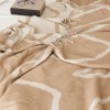 patura Sumina Crem First Choice Daily 200x220 cm cu model geometric crem alb si franjuri decorative asezata pe fotoliu