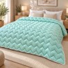 Pilota pufoasa matlasata verde menta 200x220 cm Ralex Pucioasa, cu model in zigzag si paspoal alb, asezata pe pat matrimonial