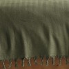 Pled Berlino Kaki 200x220cm din bumbac reciclat, cu ciucuri groși, așezat pe pat matrimonial