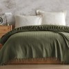 Pled Berlino Kaki 200x220cm din bumbac reciclat, cu ciucuri groși, așezat pe pat matrimonial