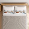 Set 2 fete de perna Craciun Home for Christmas 50x70 cm cu sat inzapezit, pod de piatra, brazi si camioneta rosie