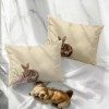 Set de 2 fețe de pernă 50x70 cm, model Maddi, cu imprimeu de iepuraș lângă un ou de Paște roz și crenguțe de salcie, pe fundal bej elegant.