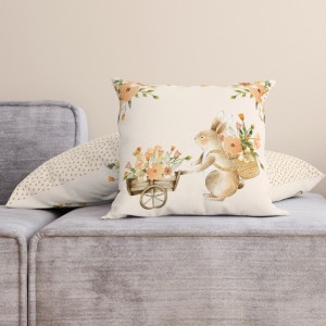Față de pernă decorativă din bumbac 100%, 45x45cm, cu un iepuraș simpatic care transportă un cărucior plin cu flori de primăvară, pe fundal crem pastelat.