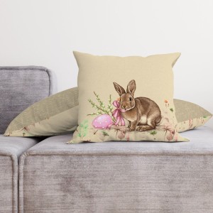 Față de pernă decorativă din bumbac 100%, 45x45cm, cu iepuraș maro, ou de Paște roz și elemente florale delicate pe fundal bej, ideală pentru decor pascal.