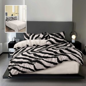 Lenjerie finet cu imprimeu zebra alb-negru si cearceaf drept crem, asezata pe pat modern