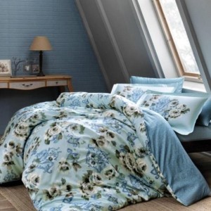 Lenjerie de pat Digital Barock TAC cu imprimeu floral albastru și alb într-un dormitor cu decor rustic.