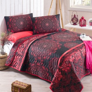 Set de pat cu model oriental în nuanțe de roșu și negru, compus dintr-o cuvertură matlasată de 200x220 cm și două fețe de pernă de 50x70 cm, aranjate într-un decor luminos cu accesorii decorative roșii