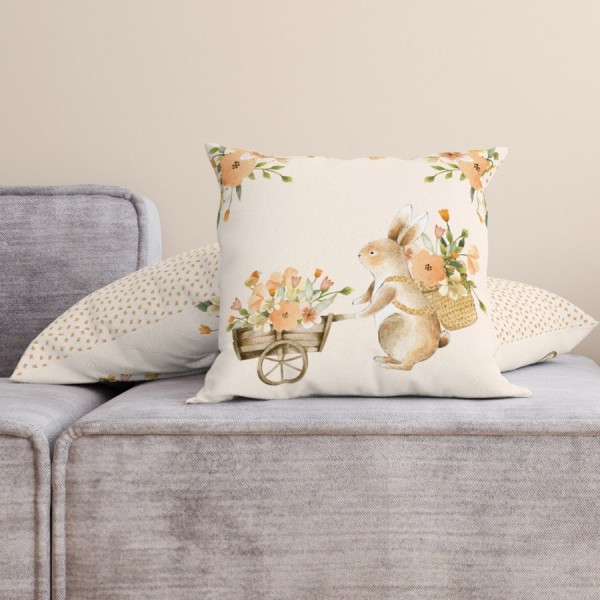 Față de pernă decorativă din bumbac 100%, 45x45cm, cu un iepuraș simpatic care transportă un cărucior plin cu flori de primăvară, pe fundal crem pastelat.