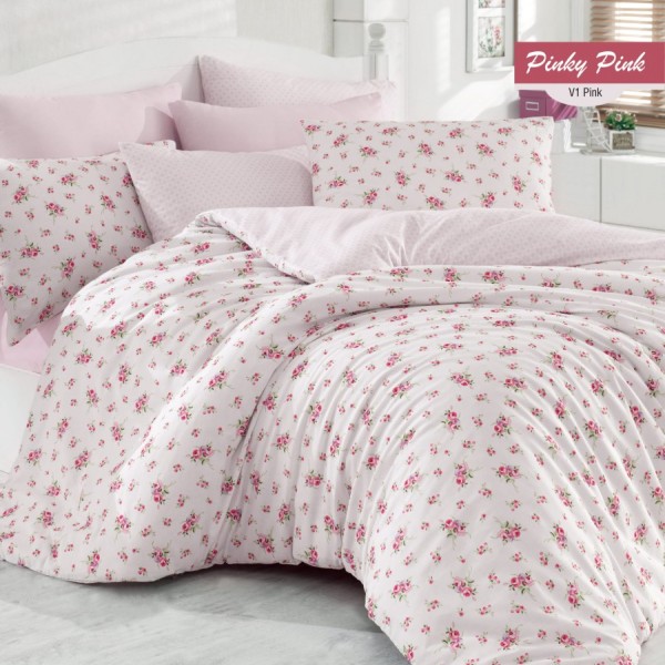 Lenjerie de pat cu design floral roz și verde pe fundal alb, completată de fețe de pernă asortate și modele mici de flori.