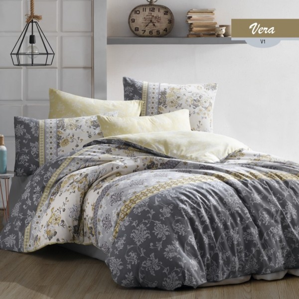 Lenjerie de pat cu design floral elegant în nuanțe de galben, gri și alb, completată de fețe de pernă asortate și modele delicate.