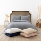 Cuvertura waffle alba 200x220cm asezata pe pat dublu, cu doua fete de perna asortate, in decor luminos si natural