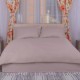 Lenjerie de pat dublu IMP17 din damasc policoton în nuanță maro V2, aranjată meticulos pe un pat într-un dormitor modern cu elemente de design elegante, invitând la relaxare și confort pentru un somn odihnitor.