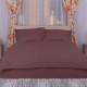 Lenjerie de pat dublu din damasc policoton IMP9 într-o nuanță subtilă de roz pastel, aranjată pe pat într-un dormitor modern, emanând o atmosferă de calm și eleganță, perfectă pentru un somn odihnitor