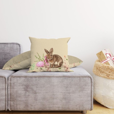 Față de pernă decorativă din bumbac 100%, 45x45cm, cu iepuraș maro, ou de Paște roz și elemente florale delicate pe fundal bej, ideală pentru decor pascal.