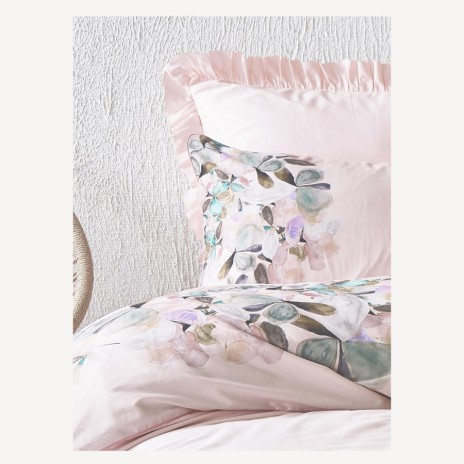 Lenjerie de pat satin premium, model Hiro, cu design floral elegant pe fundal roz pastel și volane rafinate.
