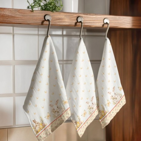 Prosop de bucătărie model Ginny din bumbac 100% cu imprimeu festiv de Paște, având iepurași, fluturi aurii și elemente florale pastelate.